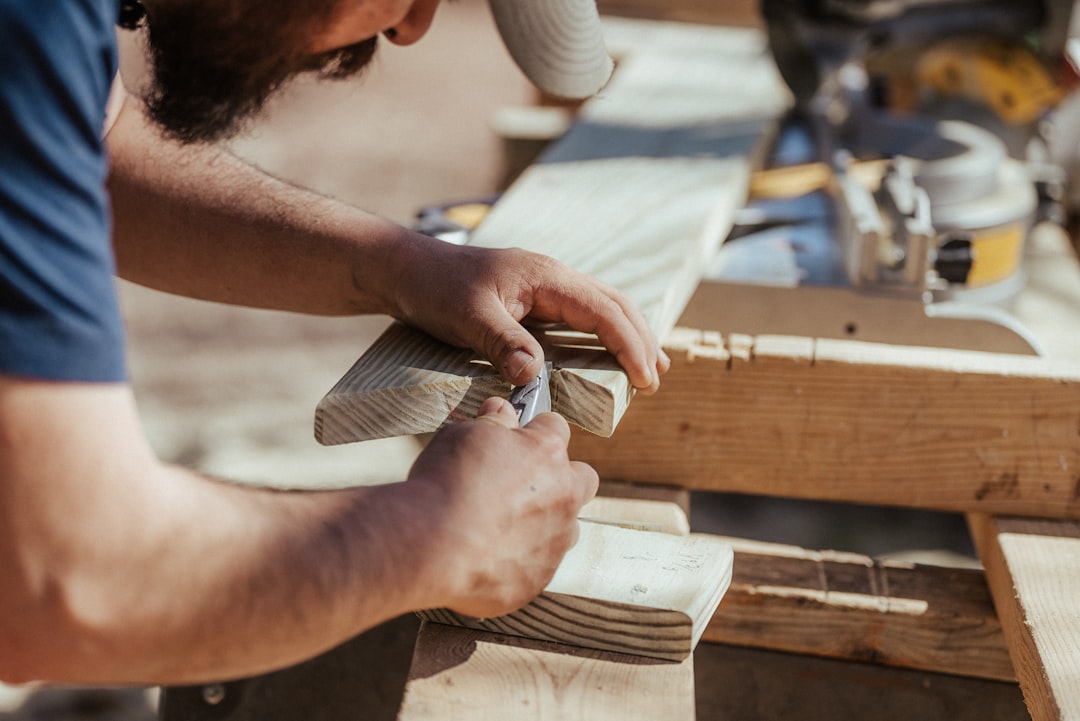 Carpenter cutting and shaping a length of timber on site
